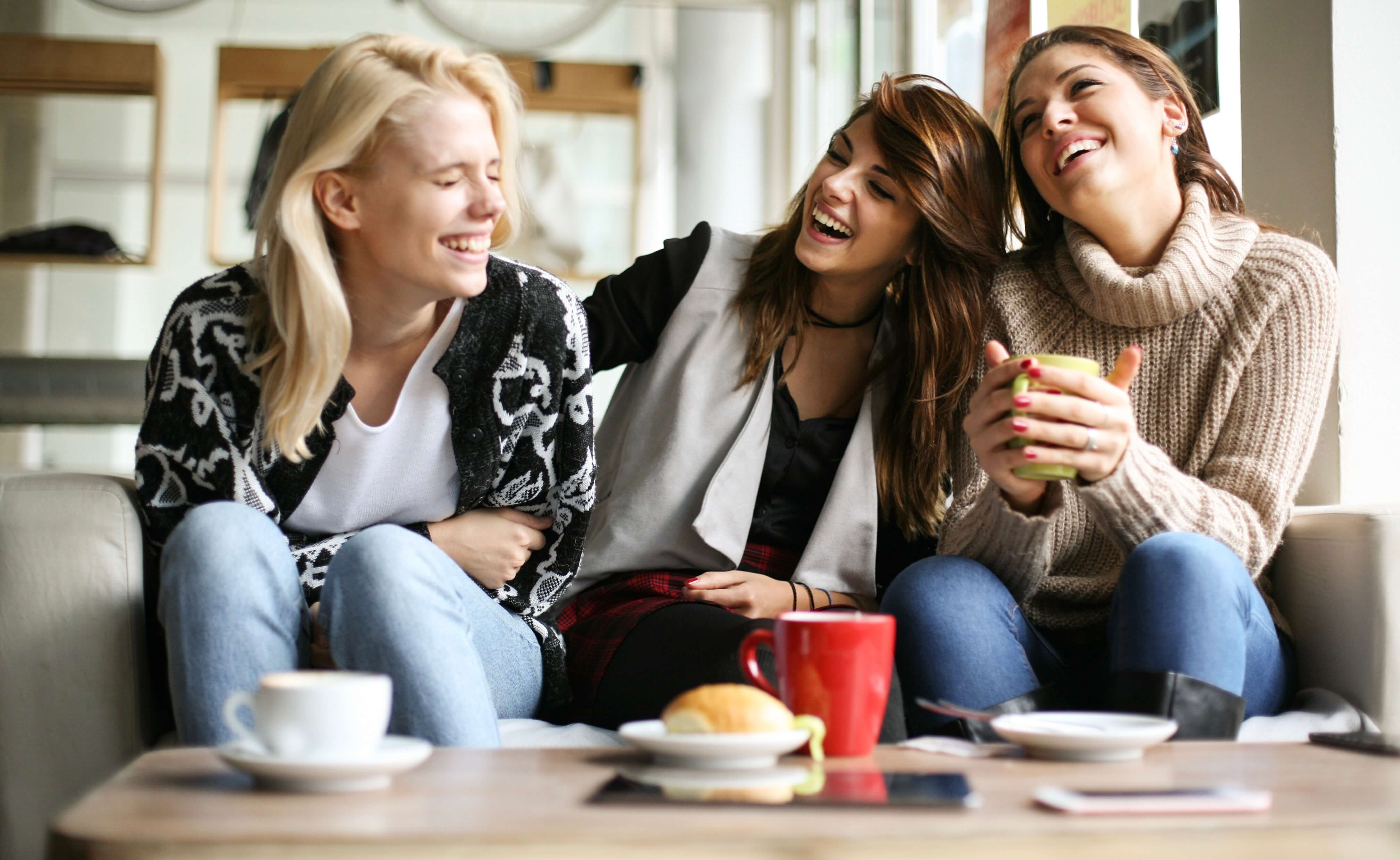 girls laughing together over coffee